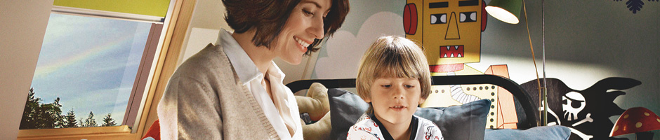 Mother reading book to son in loft conversion